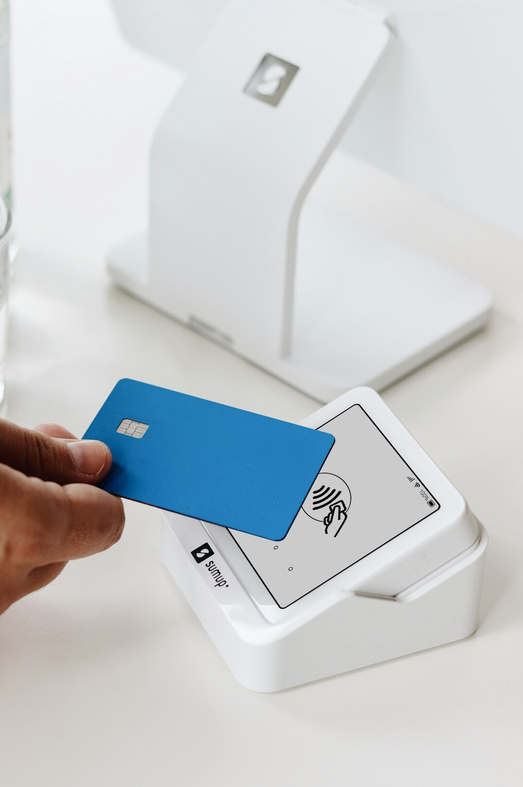 Hand holding a bank card above a payment terminal